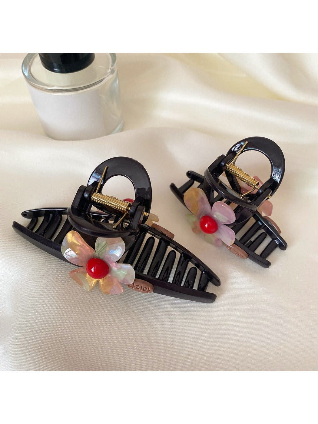 Beau crisscross flower claw clip open, displaying metal spring mechanism