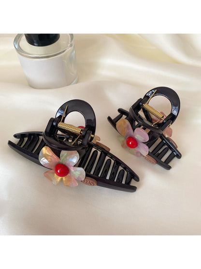 Beau crisscross flower claw clip open, displaying metal spring mechanism