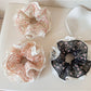 Close-up of Gifty floral print scrunchie with lace trim on a white background
