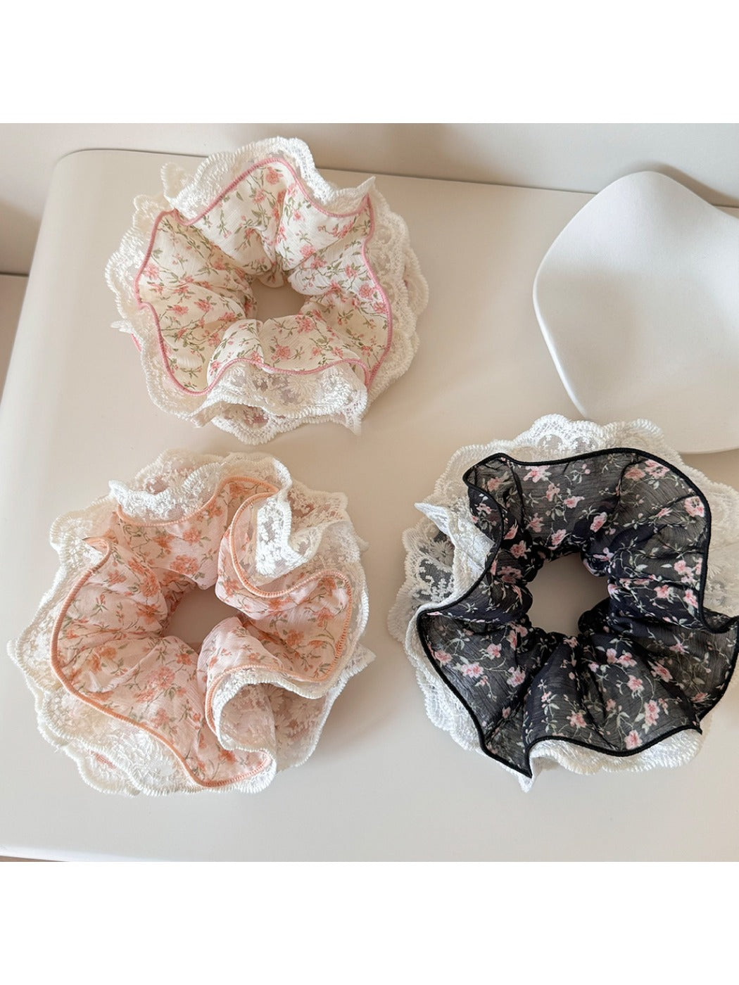 Close-up of Gifty floral print scrunchie with lace trim on a white background