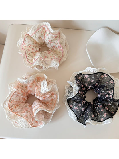 Close-up of Gifty floral print scrunchie with lace trim on a white background