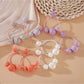 Close-up of Earedge raffia round ball earrings with woven natural fibers