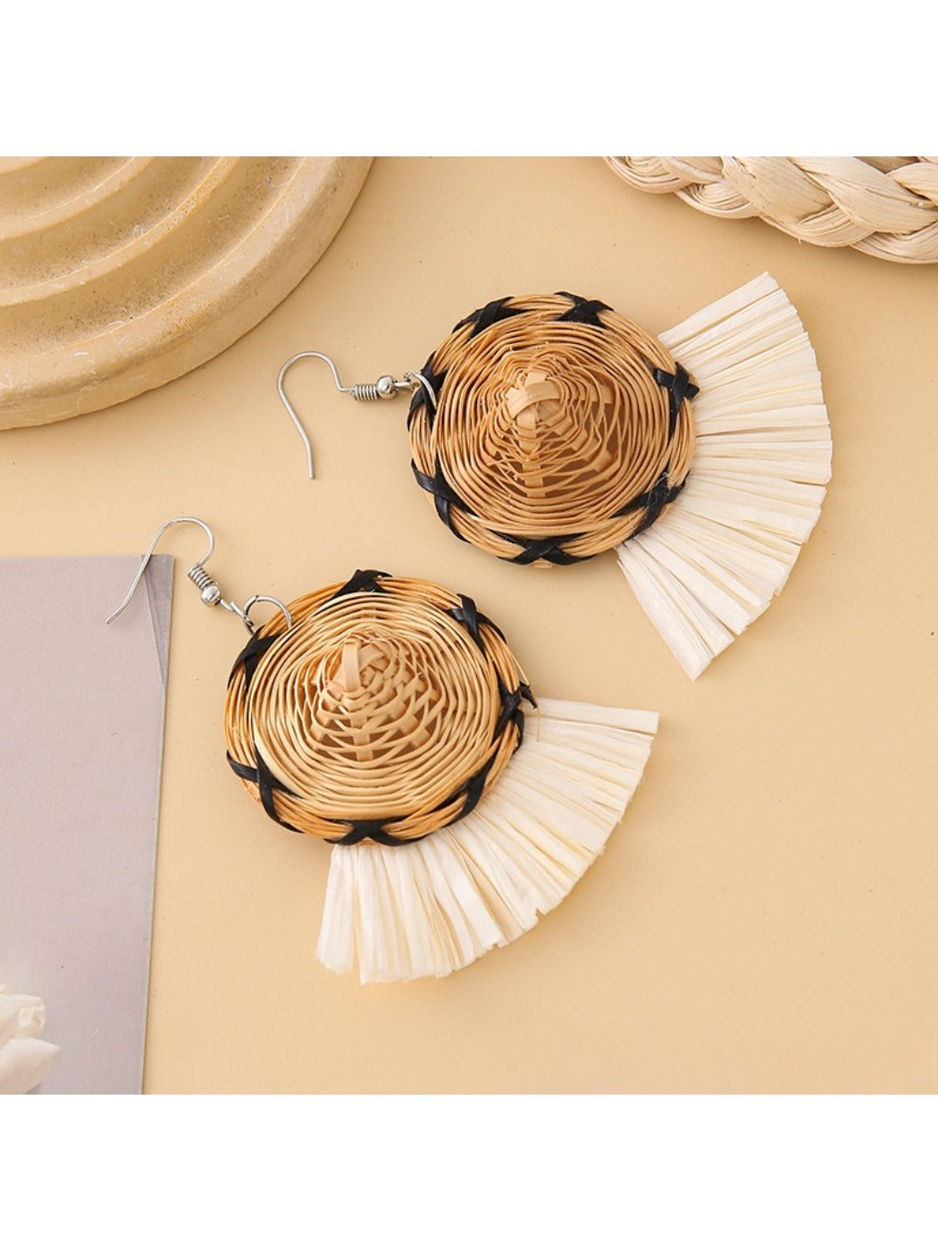 Straw hat shaped earrings shown with natural lighting and shadows