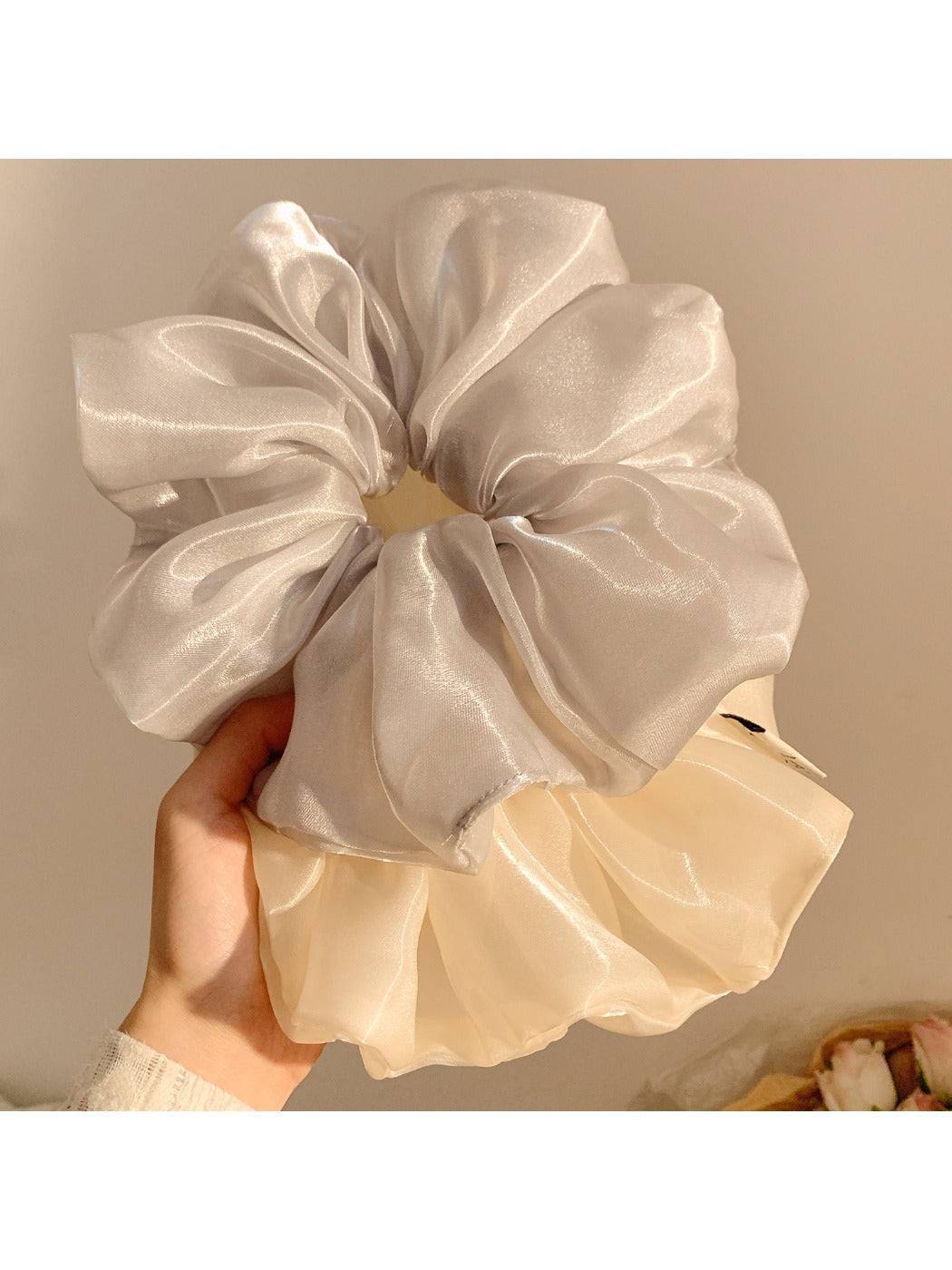 Close-up of Gifty minimalist chic shiny scrunchie in soft pink fabric