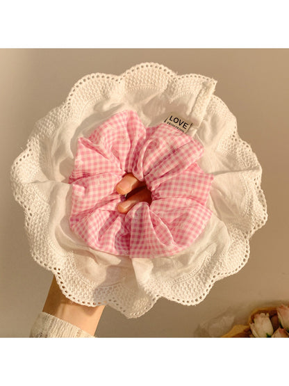 Model wearing large ruffle plaid scrunchie in hair with casual outfit