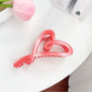 Beau claw clip resting on fabric surface showing color block design