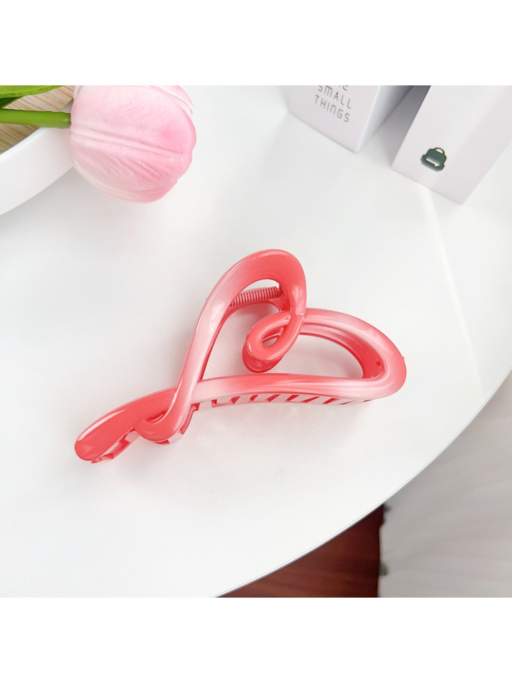 Beau claw clip resting on fabric surface showing color block design