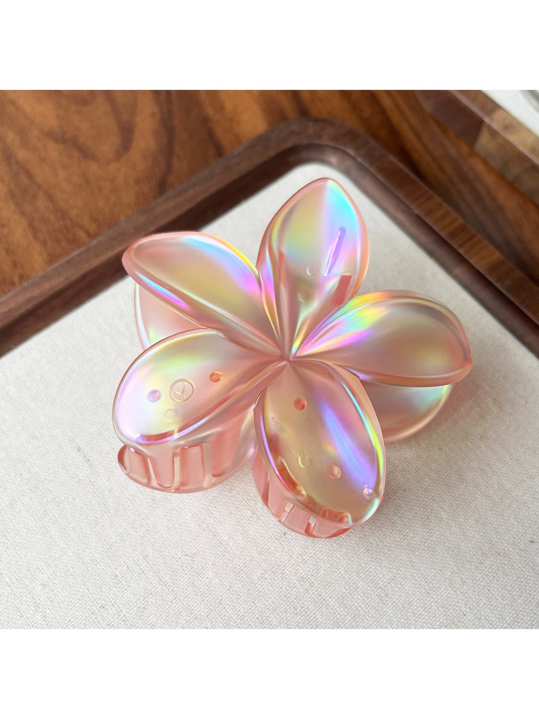 Beau flower shaped claw clip displayed in a flat lay arrangement