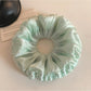 Green double layered scrunchie styled on a wrist