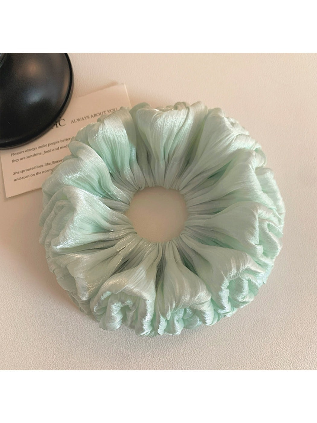 Green double layered scrunchie styled on a wrist