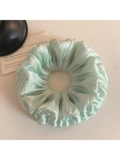 Green double layered scrunchie styled on a wrist