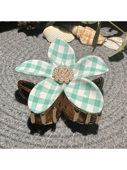 Beau checkered flower hair clip displayed on a wooden surface with natural lighting