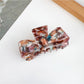Beau bow shaped claw clip with open jaws showing inner teeth