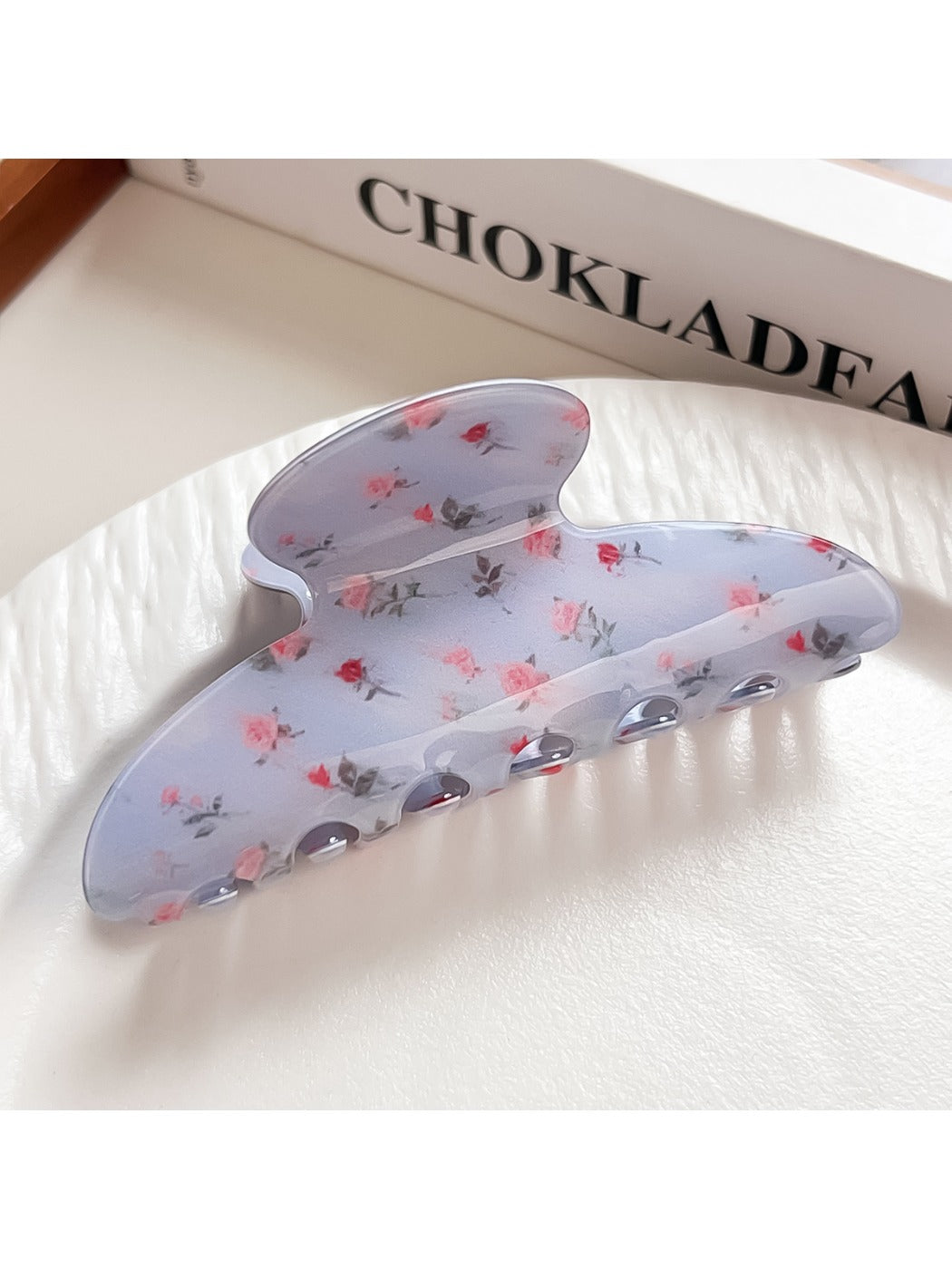 Beau blue floral shark claw clip held in hand for size reference