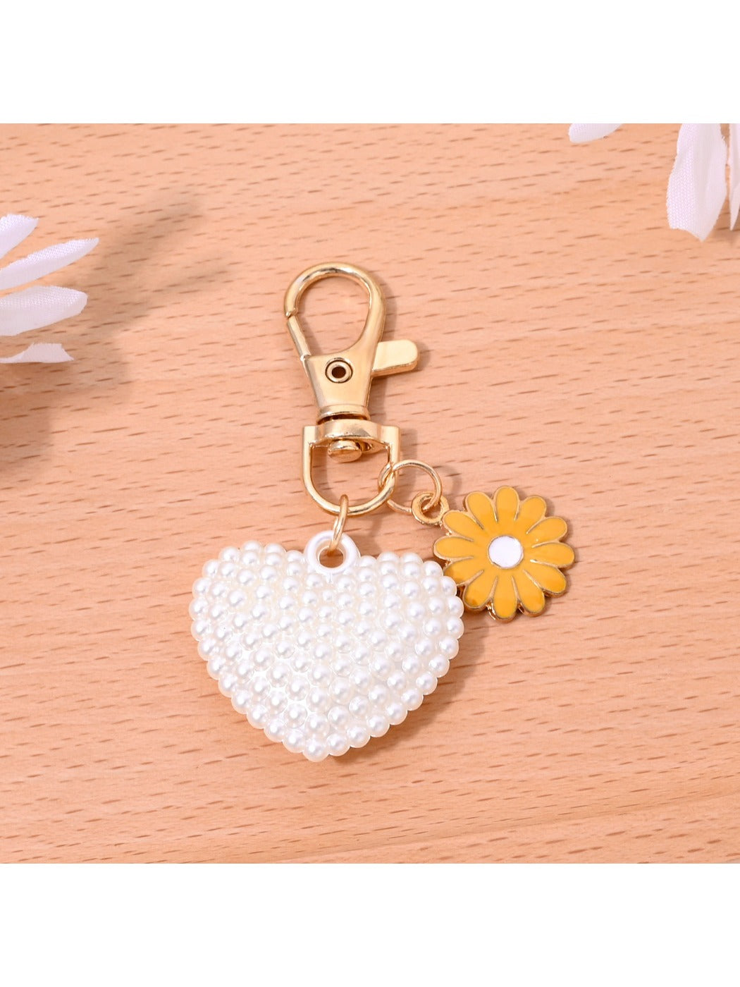 Heart shaped bag charm keychain hanging from a backpack zipper pull