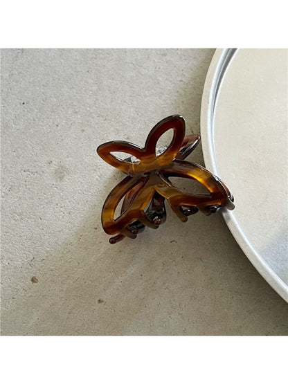 Beau Misty Acetate Butterfly Hair Clip photographed from above on neutral background