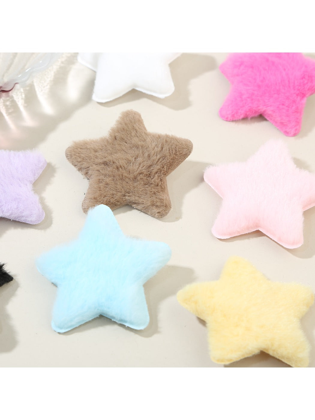 Close-up of plush star shaped hair clip showing soft texture and stitched edges