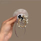 Close-up of white flower detail with layered petals on black hair tie
