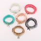 Lovra chic multi-row beaded bracelet with gold and black beads on white background