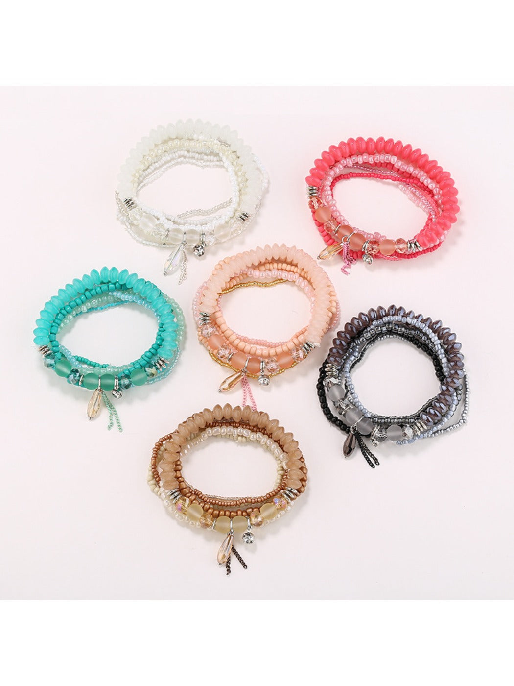Lovra chic multi-row beaded bracelet with gold and black beads on white background