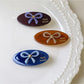 Side view of minimalist oval butterfly hair clip highlighting clip mechanism