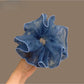 Blue plaid tulle scrunchie with ruffled texture on white background