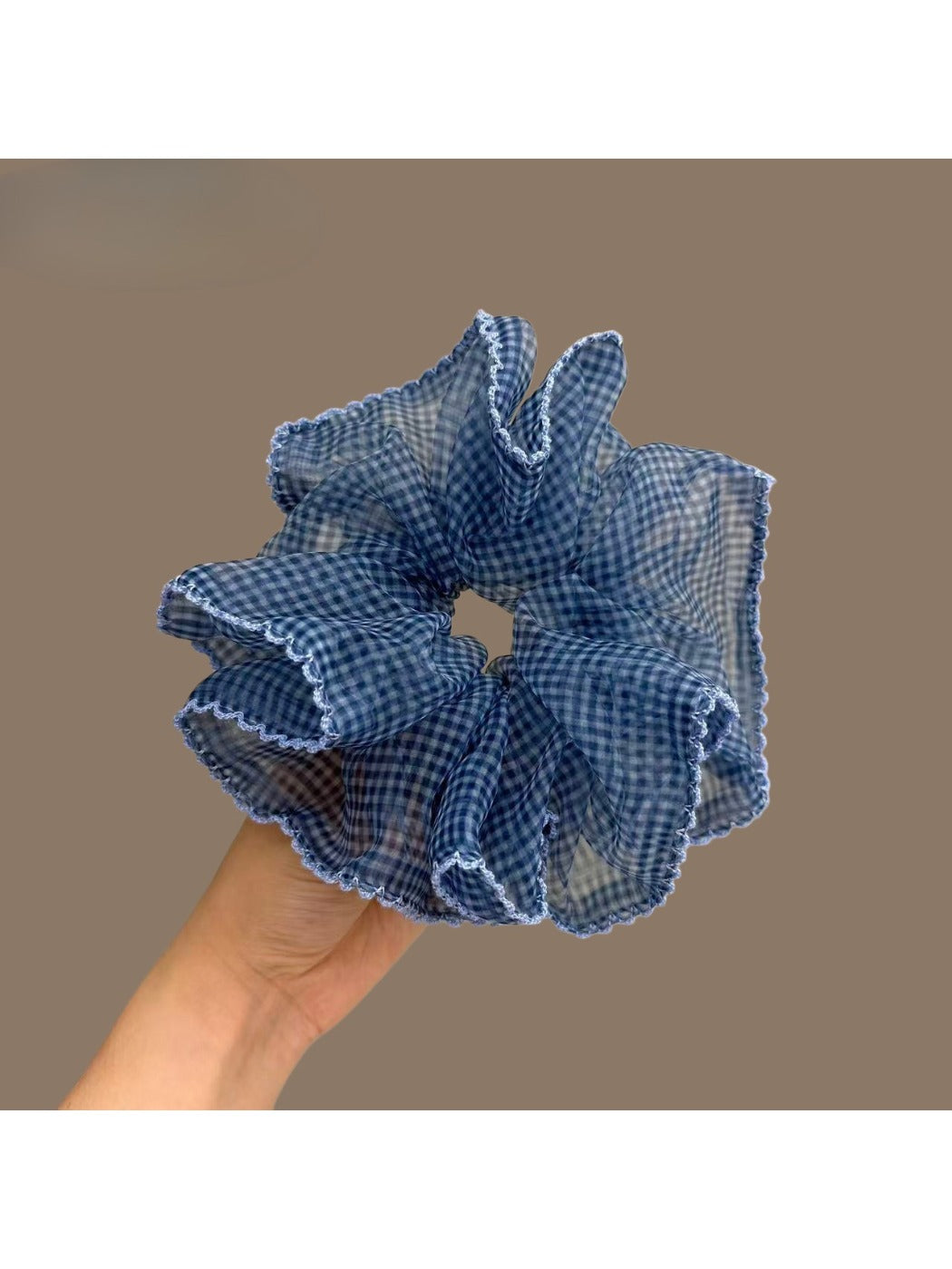 Blue plaid tulle scrunchie with ruffled texture on white background