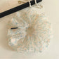 Close-up of green tulle fabric with small delicate flowers on scrunchie