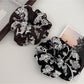 Close-up of Gifty artistic textured surface scrunchie in soft pastel colors