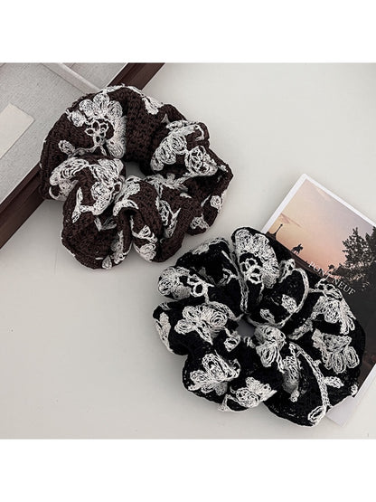 Close-up of Gifty artistic textured surface scrunchie in soft pastel colors