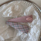 Top view of Beau oval hair clip showing glossy multicolor surface and clasp mechanism