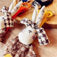 Side view of beige fabric rabbit keychain highlighting its soft texture