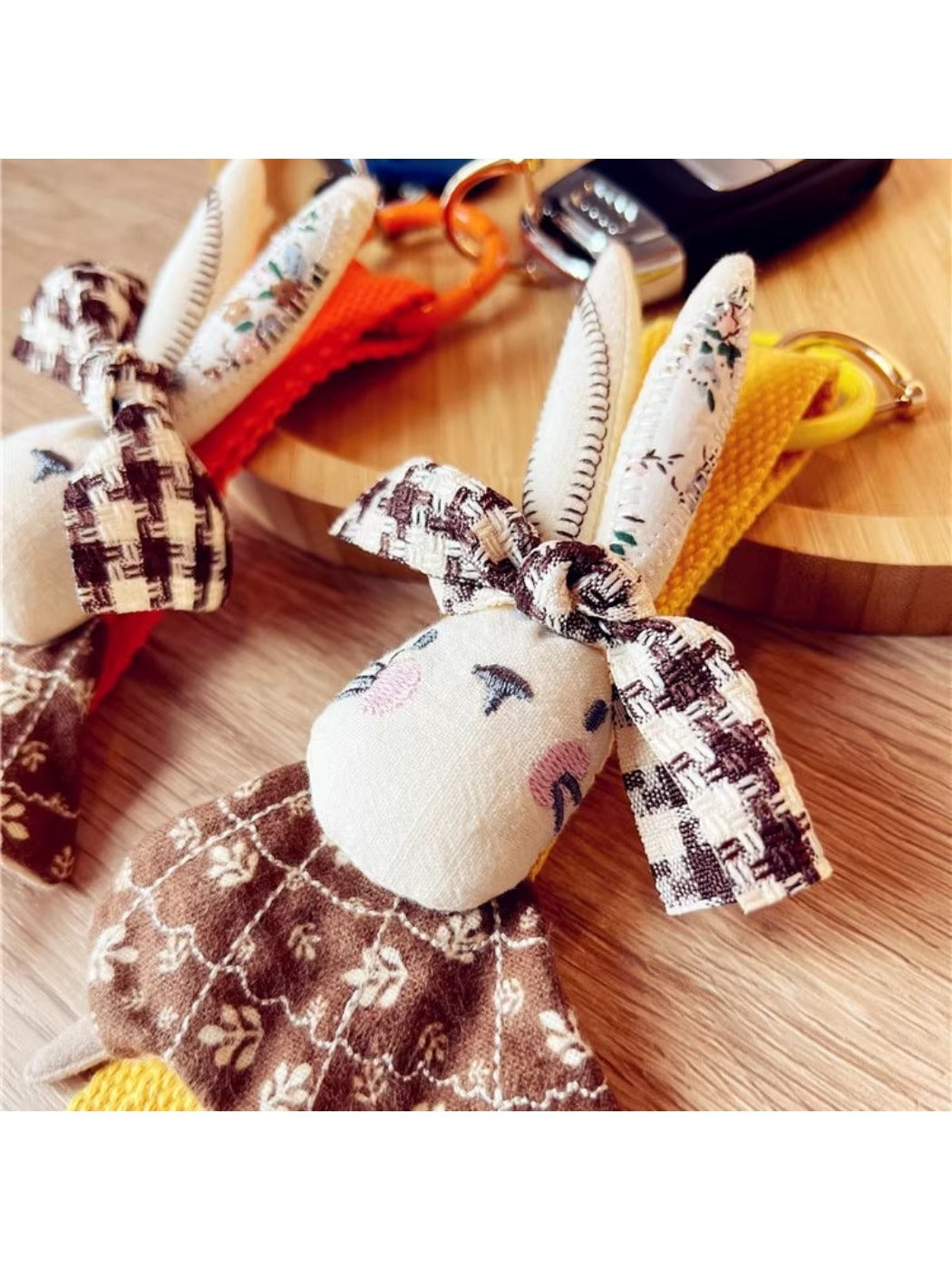 Side view of beige fabric rabbit keychain highlighting its soft texture