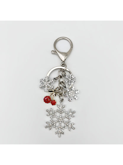 Silver snowflake keychain pendant shown with a blurred background