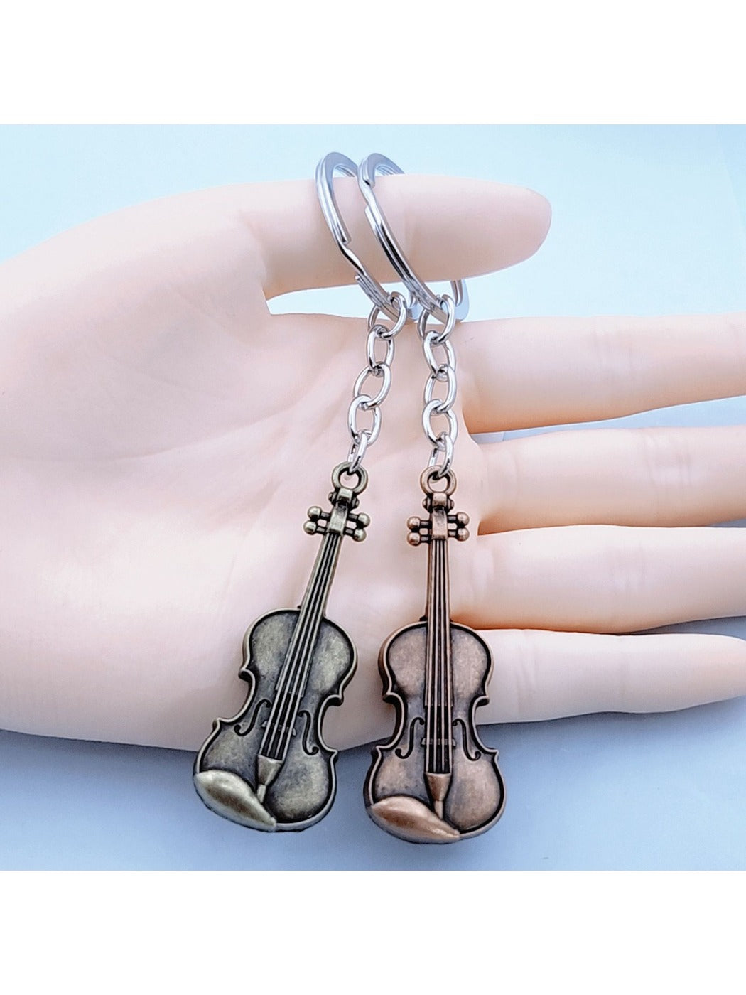 Close-up of the guitar keychain showing textured alloy surface and keyring attachment