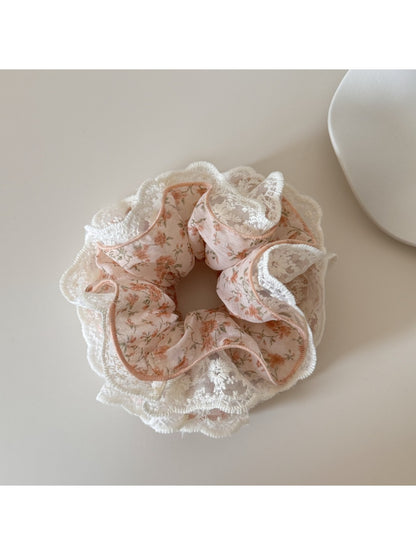 Gifty scrunchie worn on a wrist, displaying floral print and lace detail