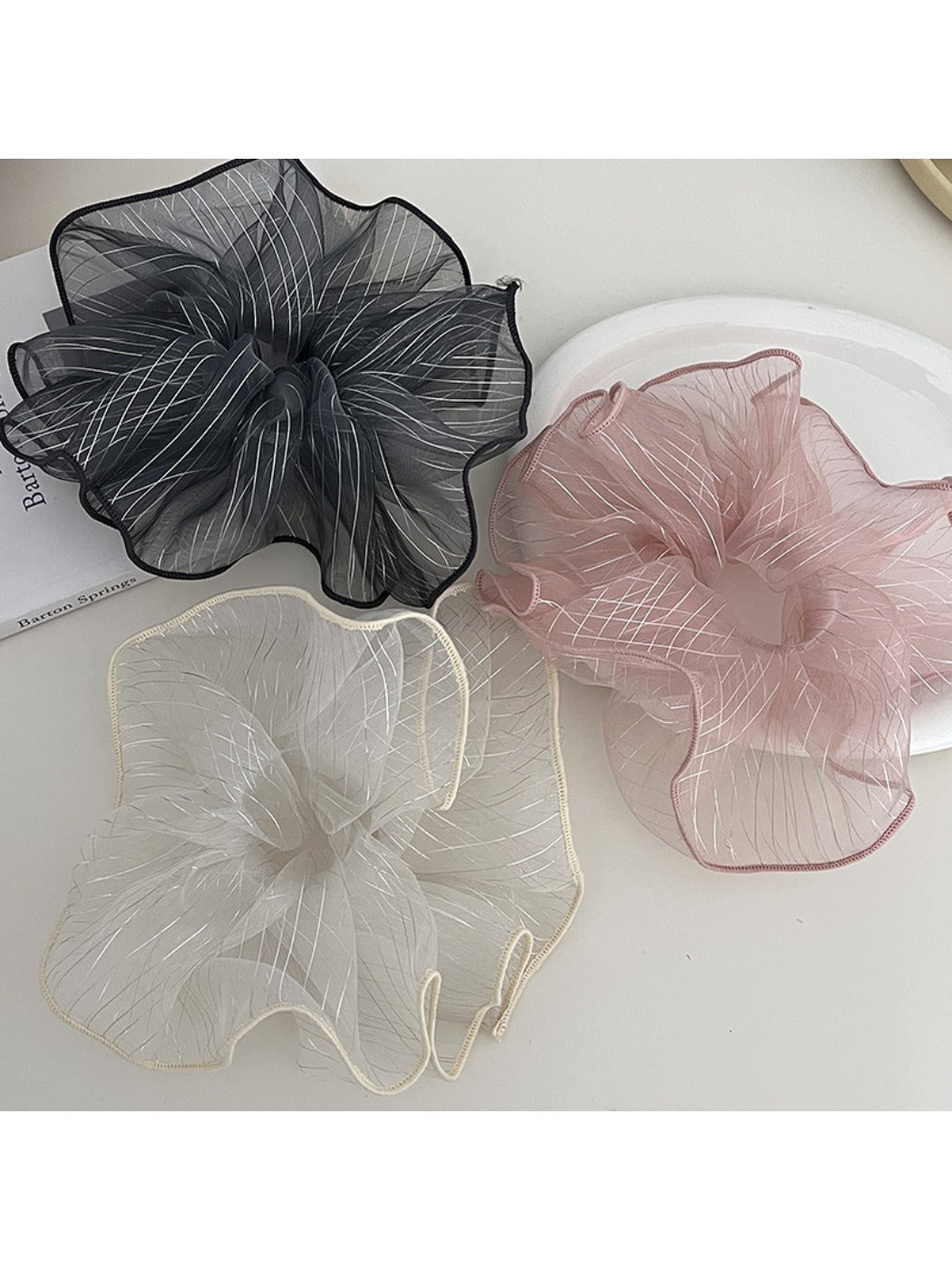 Close-up of Gifty elegant minimalist pleated scrunchie in soft beige fabric