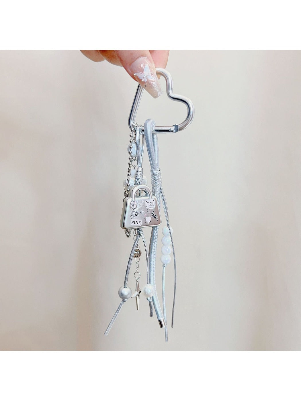 Keypus bag charm keychain attached to a handbag strap in natural lighting