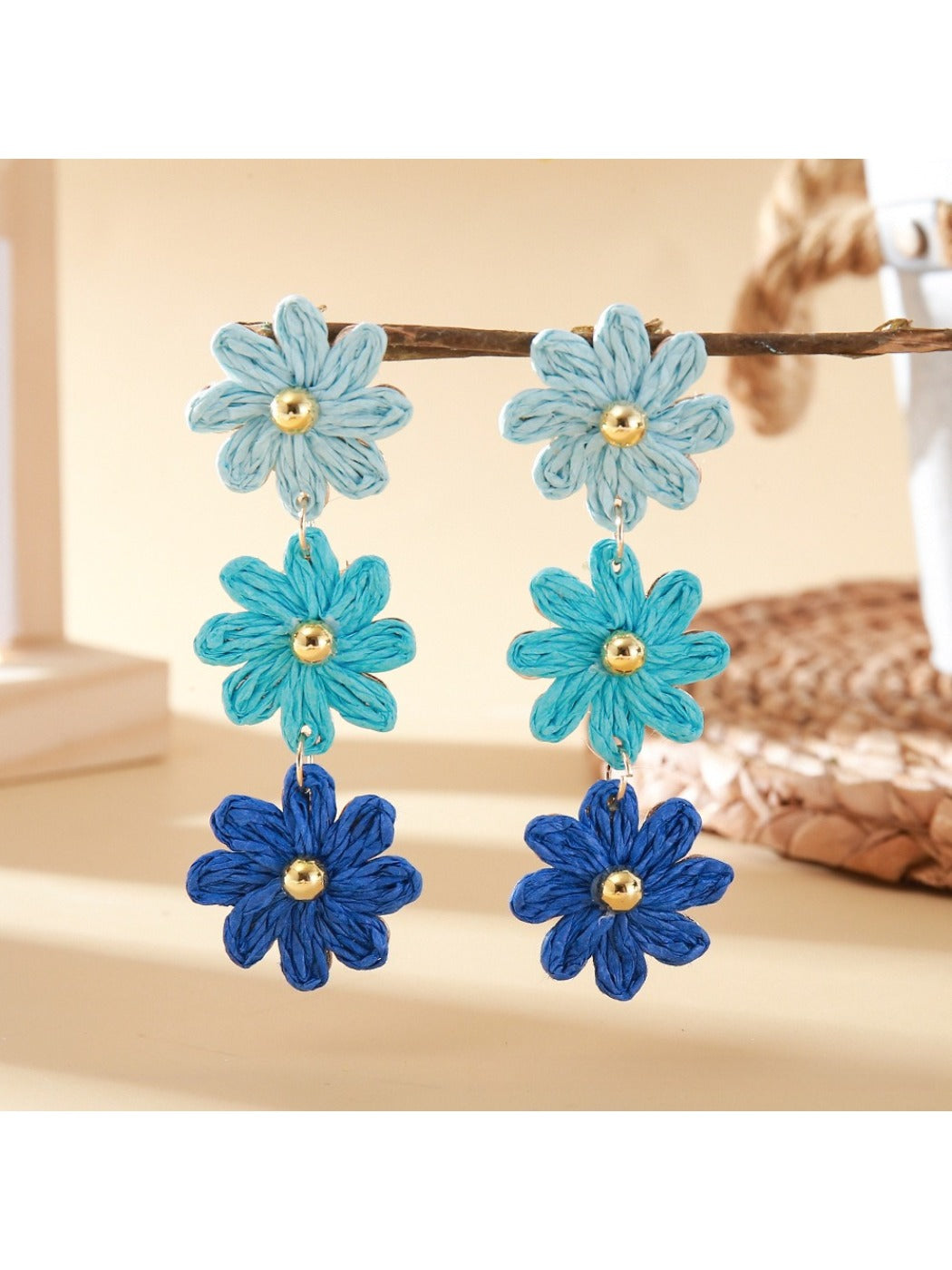 Flower shaped drop earrings with bright multicolor petals on a black surface