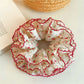 Close-up of red floral scrunchie showing fabric texture and pattern