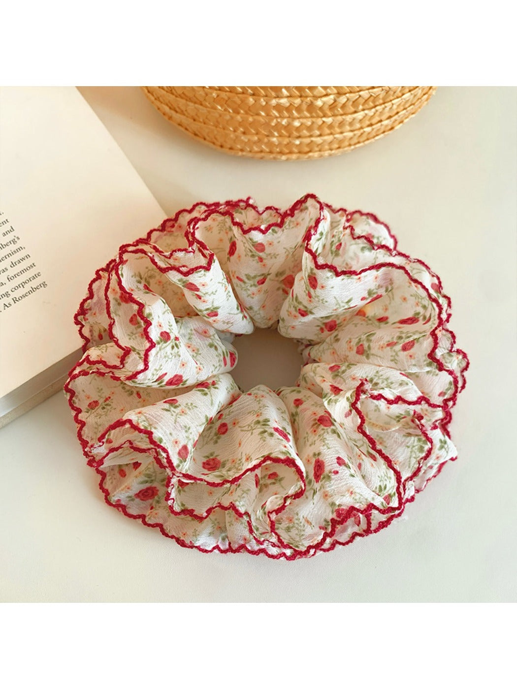 Close-up of red floral scrunchie showing fabric texture and pattern