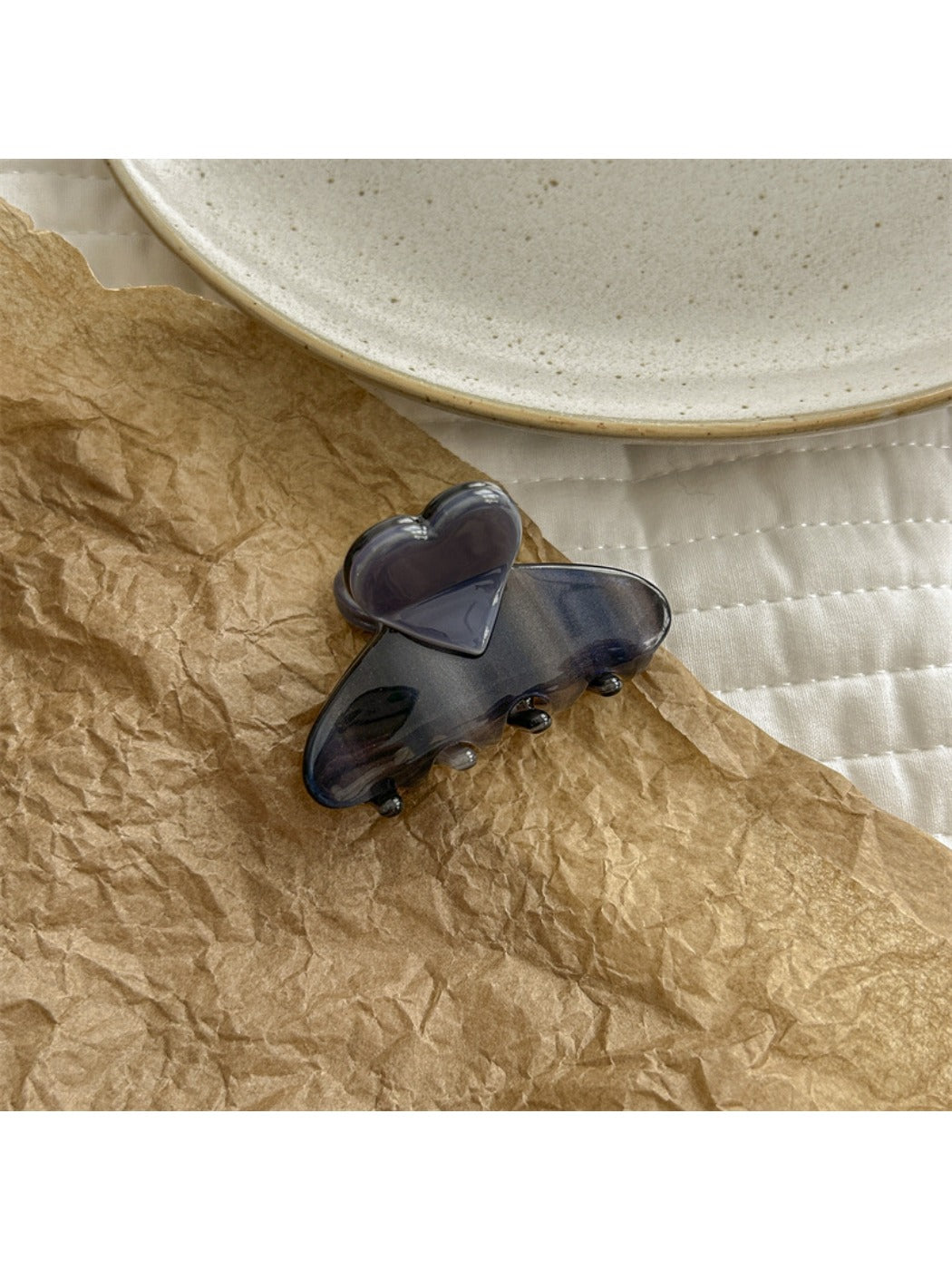 Beau heart shaped acetate claw clip with light reflecting off smooth acetate material