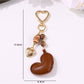 Brown heart keychain attached to a set of keys on a wooden surface