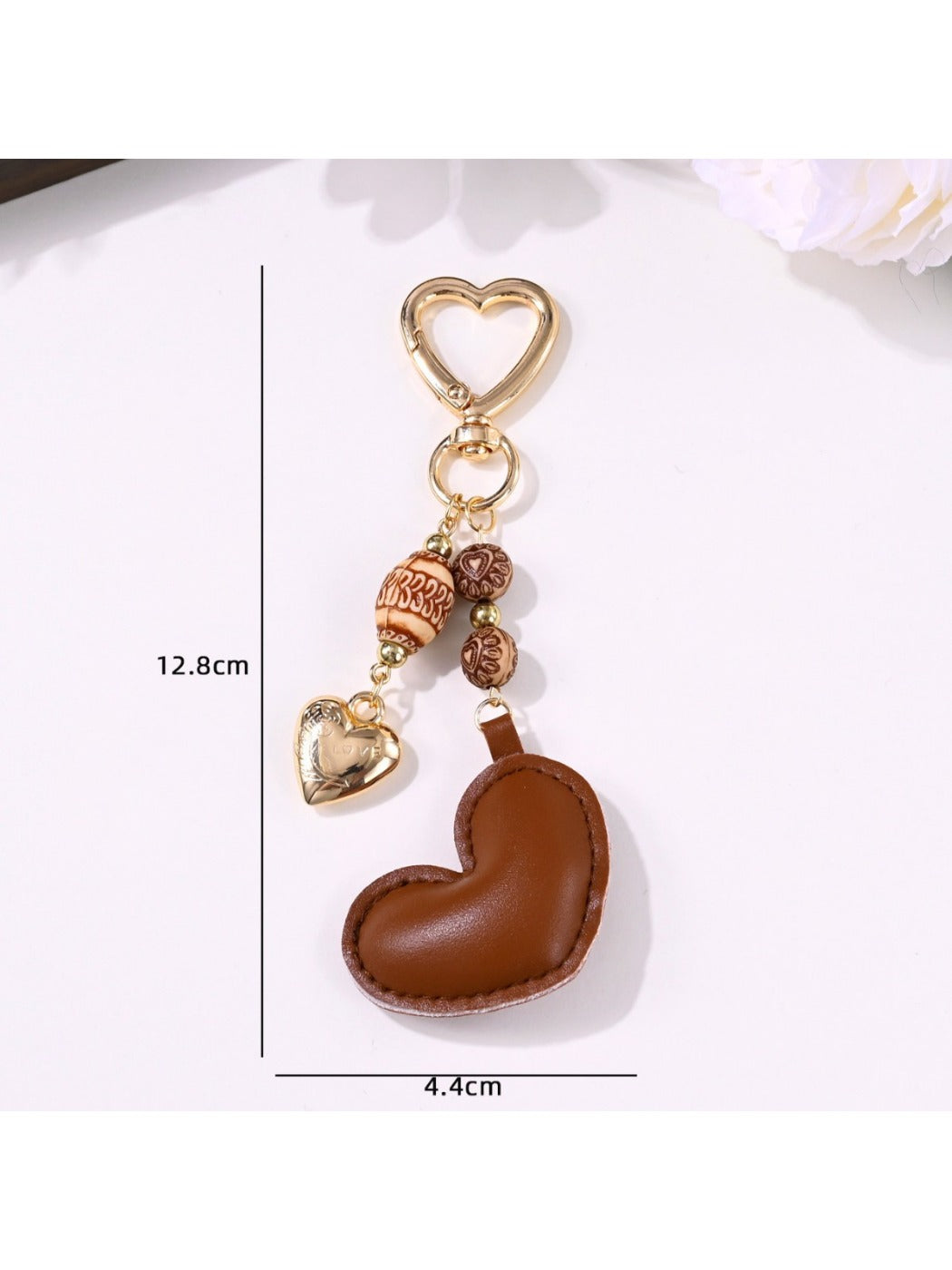 Brown heart keychain attached to a set of keys on a wooden surface