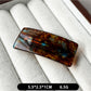 Beau curved bar hair clip clipped into dark hair with soft waves