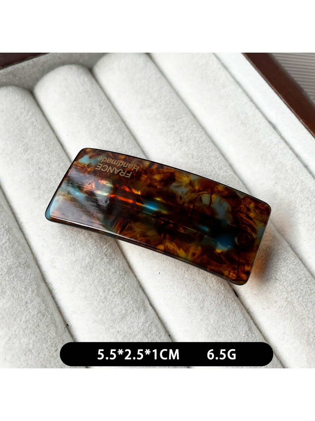 Beau curved bar hair clip clipped into dark hair with soft waves