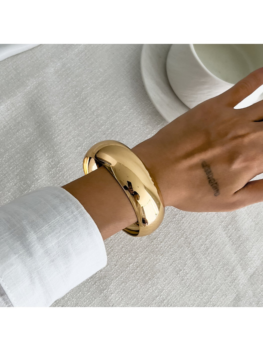 Lovra asymmetrical bangle bracelet displayed on black jewelry stand