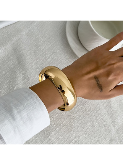 Lovra asymmetrical bangle bracelet displayed on black jewelry stand