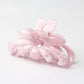 Beau flower hair clip held in hand showing size and detail