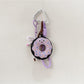 Hand holding the pink donut keychain with a blurred background